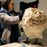 A woman stitches a chicken