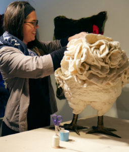 A woman stitches a chicken