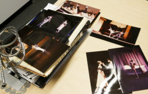 Stacks of photos of Devon performing in Romeo & Juliet are smattered across his desk.
