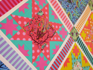 A corner of a quilt work in progress featuring Tula Pink's All Stars fabric collection.