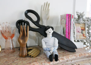 The mantle in Tula Pink's office features a collection of hand statuary, curios, and books.
