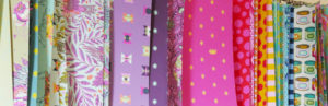 Paper printouts of Tula Pink's fabric line.