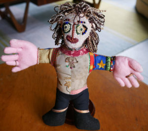 A handmade doll featuring a heavily beaded face.