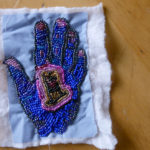 A blue beaded hand, traced off one of the nurses that Nedra worked with during her bout with cancer.
