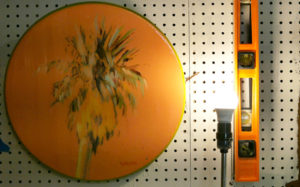 A Seth Smith palm tree painting is hung next to a coordinating level in his studio.
