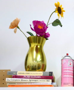 A stack of inspirational books topped with a paper floral bouquet in Grace D. Chin's studio.