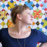 Lizzy House in front of a quilt that features her fabrics. Photo by Lizzy House.