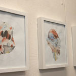 Jillian's paintings hang on the wall of her studio.