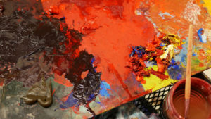A paint palette is awash in bold, bright colors, which are currently being used in a new work of Glyneisha's.