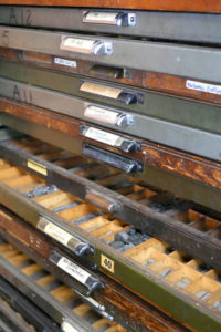 Drawers filled with different typefaces awaiting their turn in a letterpress design.
