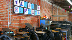 A gallery of Lego letterpress prints hang on the wall of the Two Tone Press studio.