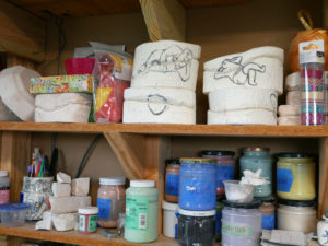 Shelves stacked with glaze in Momoko's studio.